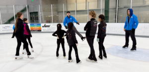 Figure skaters receiving instruction from our staff coaches